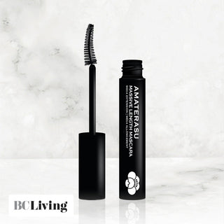 A black mascara wand is shown with bristles coated in black mascara, alongside an open mascara tube with a label.